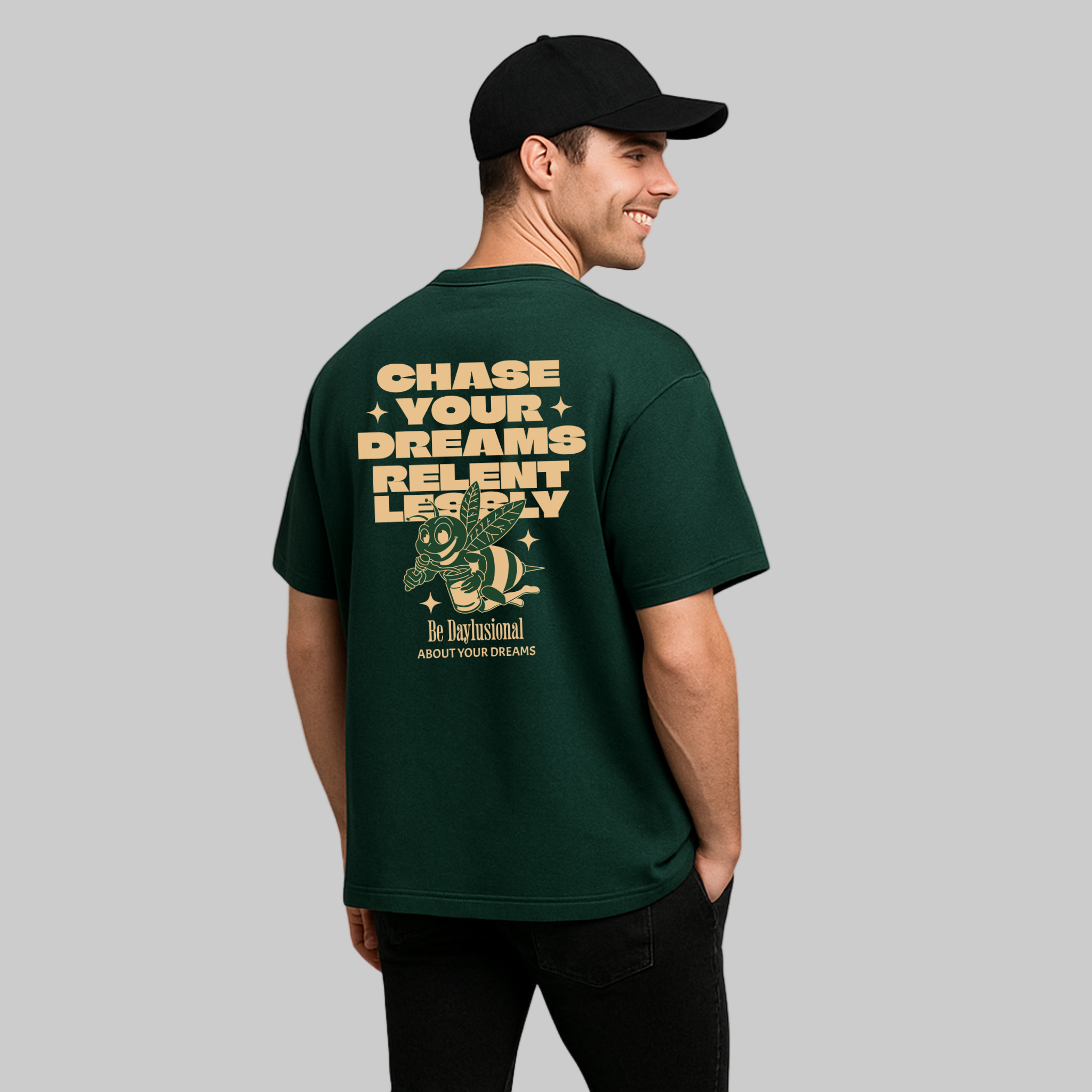Man wearing a green daylusion graphic t-shirt with motivational quote on the back, standing against a white background